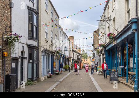 Pedestrian shopping street in Ripon, North Yorkshire, England, with independent shops, bunting and visitors in the town centre. Stock Photo
