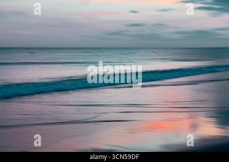 Peaceful shoreline bathed in pastel colors at twilight. Stock Photo