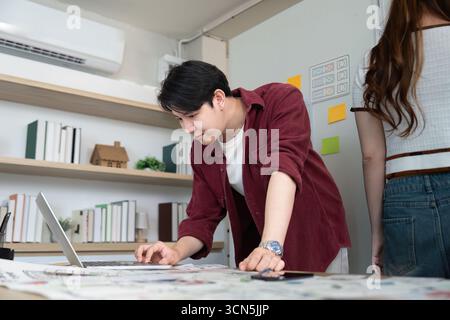 Focused Designer Working on Laptop in Creative Office Stock Photo