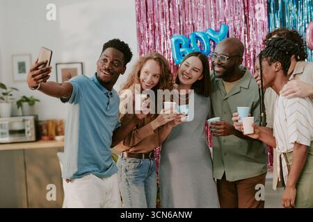 Group of Diverse Young Adults Smiling and Taking Selfie at Celebration Stock Photo