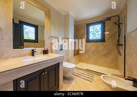 an image of a marble stone bathroom with standing shower in mediterranean home Stock Photo