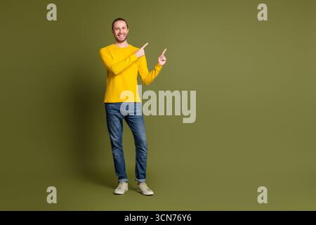 Young man in casual outfit posing confidently in front of an empty background with hand gestures for advertisement concepts Stock Photo