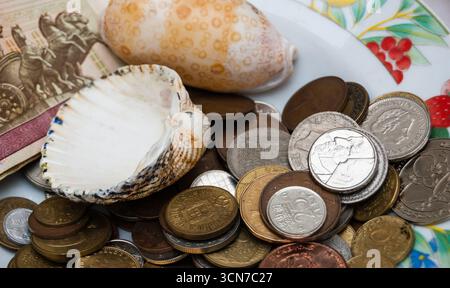 Old coins, two shells, and Russian banknotes on at flea market in Paris, France. Stock Photo