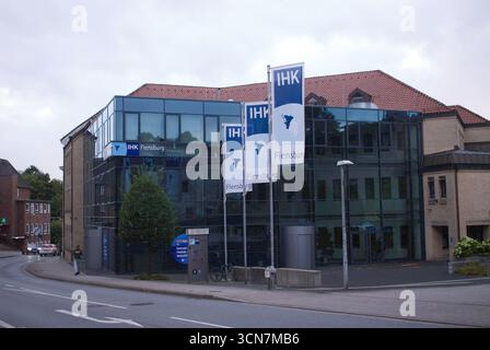 Flensburg, Schleswig-Holstein Gebäude der Industrie- und Handelskammer IHK Flensburg an einer Straßenecke in Flensburg. Die Architektur verbindet Glasfassaden mit traditionellen Backstein-Elementen, davor wehen drei Fahnen mit IHK-Emblem und dem Schriftzug Flensburg. Im Vordergrund verläuft eine Straße mit Gehweg, es stehen ein Baum, ein Fahrradbügel und Straßenlaternen, während im Hintergrund weitere Gebäude zu sehen sind. Aufnahme vom 19.09.2025, Flensburg *** Flensburg, Schleswig Holstein Building of the Chamber of Industry and Commerce IHK Flensburg on a street corner in Flensburg The arch Stock Photo