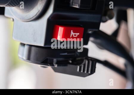 Close-up of a camera control panel showing a red button and a black dial. The focus is on the details of the equipment used for photography. Stock Photo