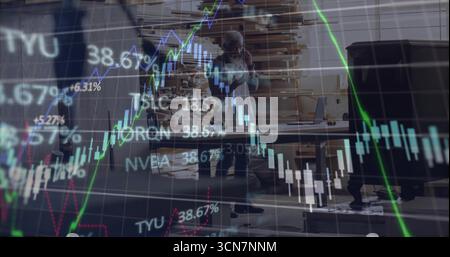 Holding smartphone to ear man tracking stock market graphics at woodshop, with planks and laptop Stock Photo