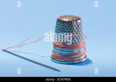 Sewing needles, thread, scissors, and thimbles. Stock Photo