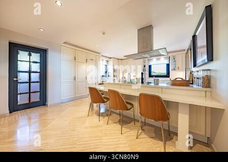an image of a dining area next to open kitchen in luxury real estate property Stock Photo