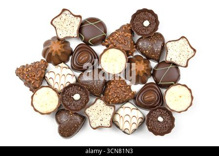 A large assortment of chocolate truffles are displayed on a white background. The truffles come in various shapes and sizes, including hearts, stars, Stock Photo