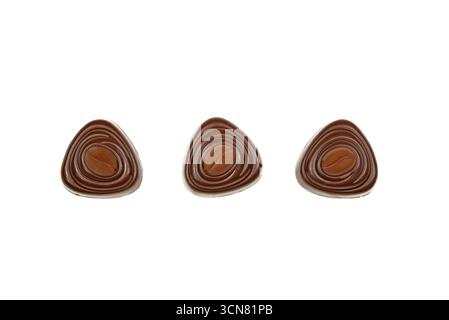 Three chocolate truffles with a coffee bean design. The truffles are arranged in a row on a white background Stock Photo
