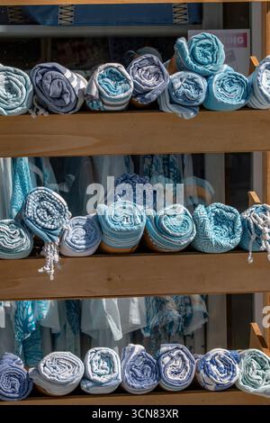 rolled up towels and beach mats on sale at a Greek gift shop on the Ionian Island of Zante or Zakynthos in Greece. Abstract of rolled towels Stock Photo