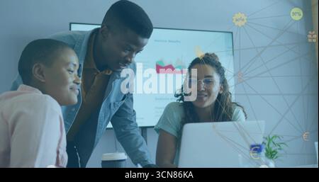 Collaborating coworkers analyzing data on laptop at office, with charts on display and coffee cup Stock Photo