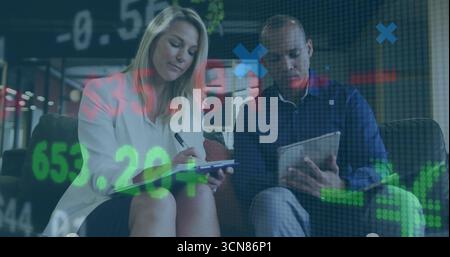 Analyzing financial charts overlay, coworkers sitting in workspace lounge with tablet clipboard pen Stock Photo