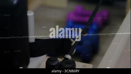 Braided cable assembly moving through metal guide on wooden block in workshop, with support rollers Stock Photo