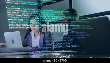 Software team analyzing code on glass screen in tech workspace, with laptop coffee mug and papers Stock Photo