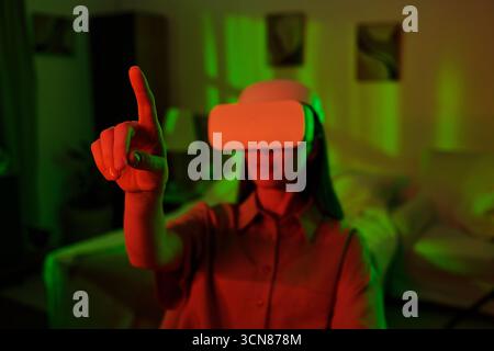Woman Using Virtual Reality Headset Interacting Indoors Stock Photo