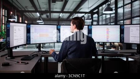 Senior Accountant Calculating Taxes On Electronic Spreadsheet In Office Environment. Stock Photo