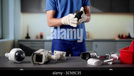 Skilled Technician Setting Up Surveillance Camera For Building Security System. Stock Photo
