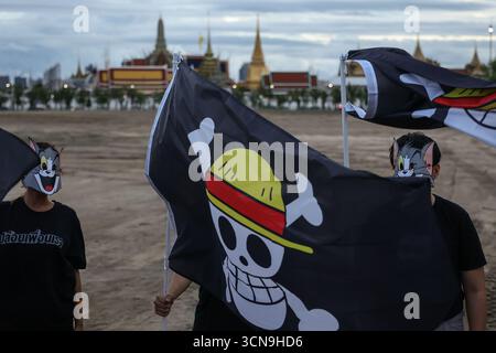 Bangkok, Bangkok, Thailand. 19th Sep, 2025. Anti-government protesters in Thailand held black flags bearing the image of a skull with a straw hat ""” a symbol of the pirate crew from the Japanese anime One Piece, representing defiance against dictatorship and the fight for freedom. The symbol was used as a form of political expression, with the Grand Palace as the backdrop, on September 19, 2025. (Credit Image: © Nattaphon Phanphongsanon/ZUMA Press Wire) EDITORIAL USAGE ONLY! Not for Commercial USAGE! Stock Photo