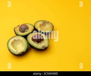 Close up of sliced Avocados placed on a yellow background Stock Photo