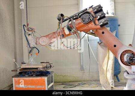 Robot working on milling sculpture in natural stone Stock Photo