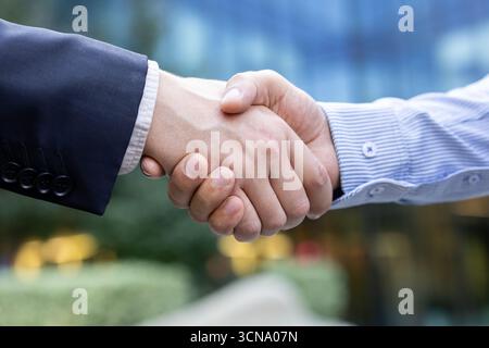 Two business professionals shake hands in a corporate setting, sealing a deal and symbolizing trust, collaboration and commitment between partners during a meeting Stock Photo