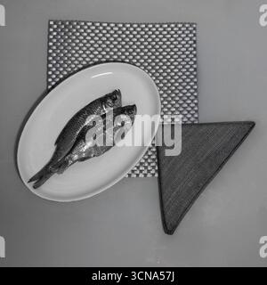 Dried Fish on Plate with Geometric Background Monochrome. Stock Photo