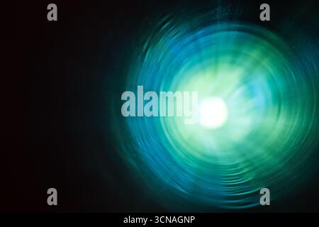 A vibrant and colorful abstract depiction of a tunnel with radiant green and blue light emanating from the center, creating a sense of mystery, energy Stock Photo