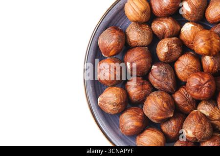Bowl with hazelnuts on white background. Natural healthy nuts closeup. Organic food rich in protein and nutrition. Vegan snack option. Stock Photo