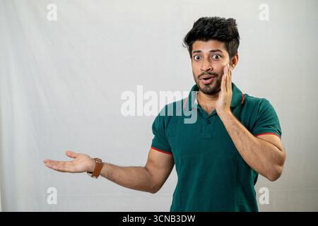 A young man with a surprised expression, with his hands gesturing. Stock Photo