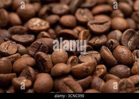 A close up of coffee beans with a grainy texture. The beans are brown and appear to be freshly roasted Stock Photo