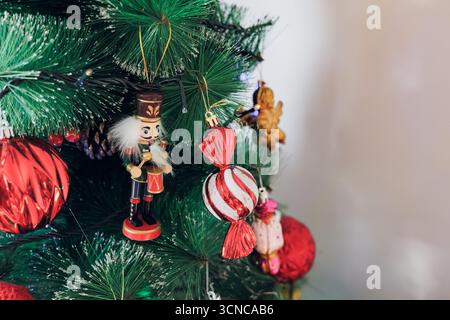 A decorated Christmas tree with a nutcracker and ornaments by a window Stock Photo