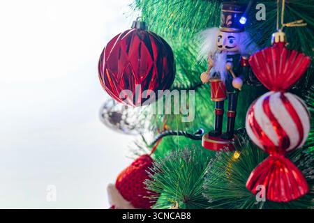 A decorated Christmas tree with a nutcracker and ornaments by a window Stock Photo