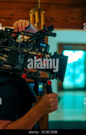 Cinematic camera rig filmmaker handheld setup during indoor video production. Close-up of professional film equipment used for high-quality cinematogr Stock Photo