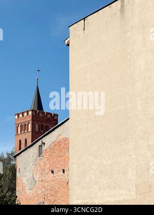 Minimalist modern plaster wall in front with a historic castle tower in the background. The image contrasts contemporary and medieval architecture wit Stock Photo