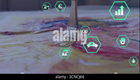 Paintbrush with wood handle applying red paint on canvas in art studio, with green hexagon icons Stock Photo