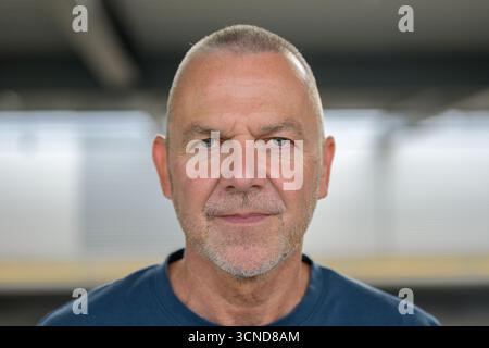 Close-up portrait of a confident middle-aged man with short gray hair and a calm expression. Stock Photo