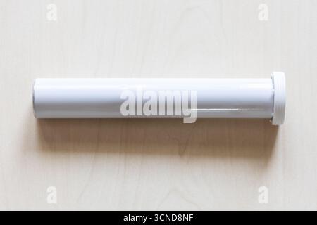 closed blank white cylindrical container for effervescent pills on wooden board Stock Photo