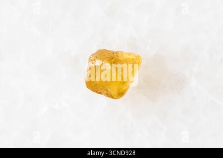 sample of raw jargoon zircon crystal on white marble background close up from Cambodia Stock Photo