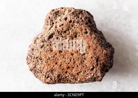 sample of raw brown pumice mineral on white marble background close up Stock Photo
