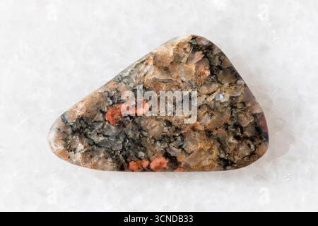 sample of polished gneissoid granite rock on white marble background close up from Karelia, Russia Stock Photo