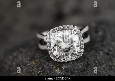 A large diamond ring with a halo of diamonds. The ring is set in a black stone Stock Photo