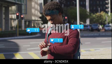 Checking man gazing at smartwatch on street corner, with headphones, backpack, notification icons Stock Photo