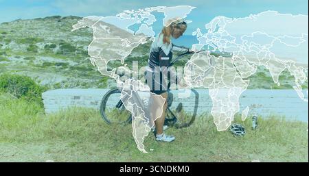 Using hand pump female cyclist in cycling gear inflating tire on grassy path, with helmet Stock Photo