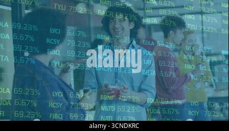 Chatting coworkers holding red coffee mug, smartphone and laptop in modern office lounge area Stock Photo