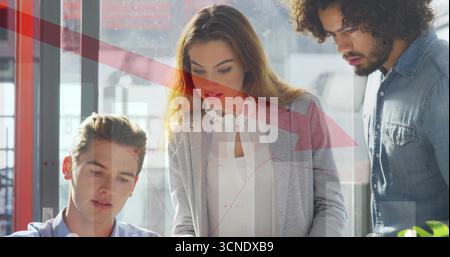 Reviewing documents and analyzing chart overlays, team in office attire collaborating around desk Stock Photo