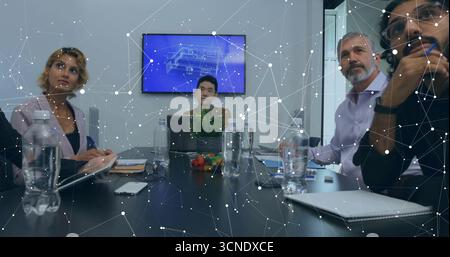 Collaborating professionals analyzing technical blueprint display in meeting room, with laptop Stock Photo
