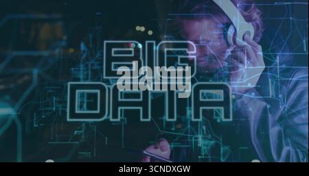 Adjusting headphones man wearing suit jacket holding smartphone in lab, with holographic data Stock Photo