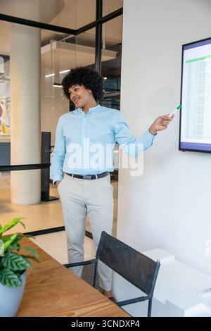 African american man presenting spreadsheet on flat screen in conference room using marker Stock Photo