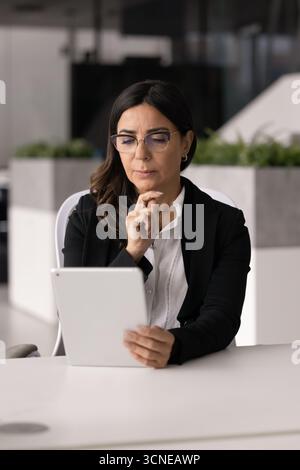 Serious thoughtful mature businesswoman thinking on solutions for online product Stock Photo
